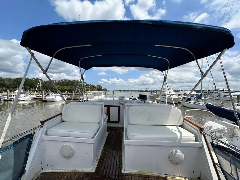 Slide: The Image of 1974 Grand Banks 32 Sedan boat with canopy, docked at marina under blue sky. - 13