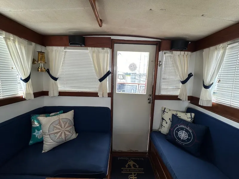 Slide: The Image of Interior of a 1974 Grand Banks 32 Sedan with nautical-themed cushions and curtains. - 17