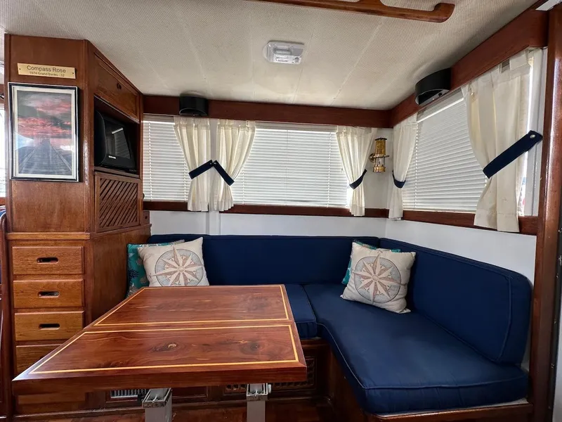 Slide: The Image of 1974 Grand Banks 32 Sedan interior with blue seating, wooden table, and nautical decor. - 18