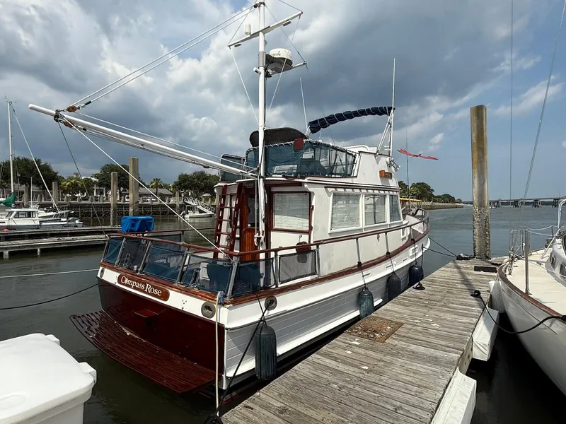 Slide: The Image of 1974 Grand Banks 32 Sedan docked at marina under cloudy sky. - 2