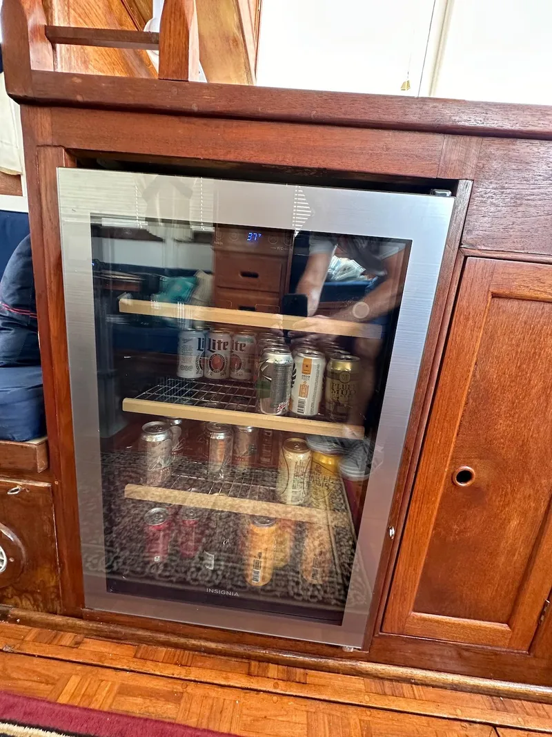 Slide: The Image of Mini fridge stocked with beverages inside a 1974 Grand Banks 32 Sedan boat. - 22