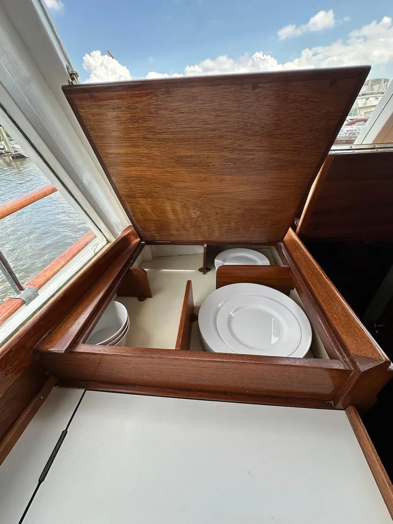 Slide: The Image of 1974 Grand Banks 32 Sedan interior with wooden storage compartment and plates. - 23