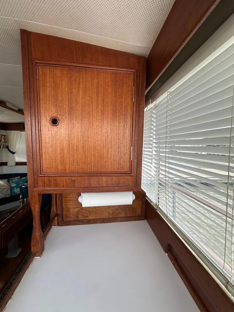 Slide: The Image of 1974 Grand Banks 32 Sedan interior with wooden cabinetry and window blinds. - 24