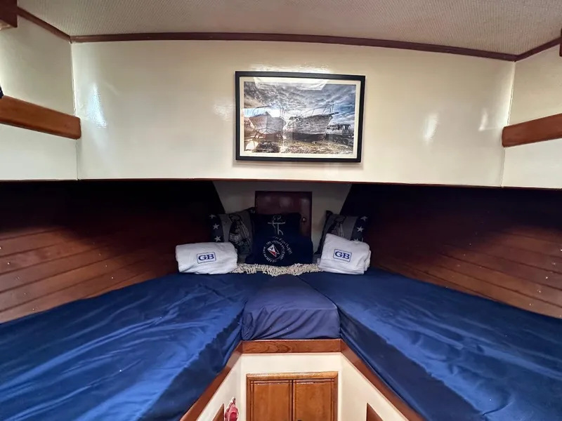 Slide: The Image of 1974 Grand Banks 32 Sedan cabin with blue bedding and nautical decor. - 32