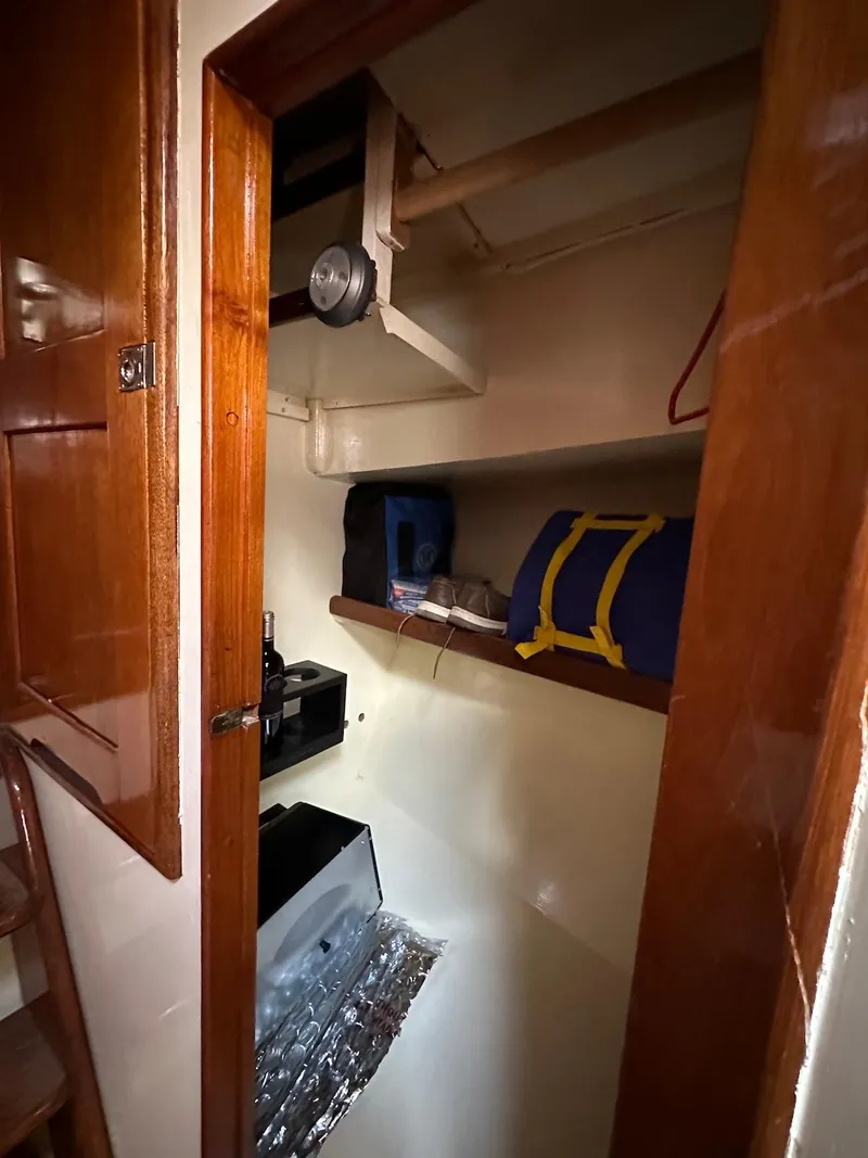 Slide: The Image of 1974 Grand Banks 32 Sedan interior storage space with shelves and equipment. - 33