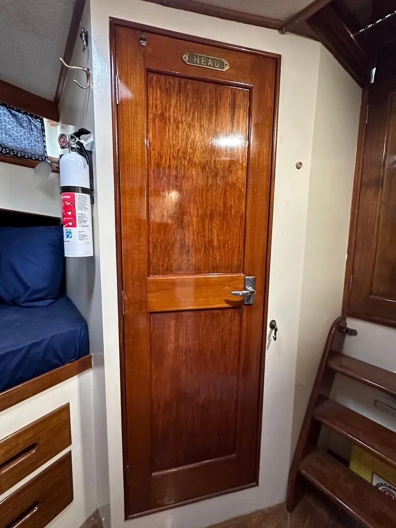 Slide: The Image of 1974 Grand Banks 32 Sedan interior with wooden door labeled "HEAD" and adjacent bunk bed. - 35