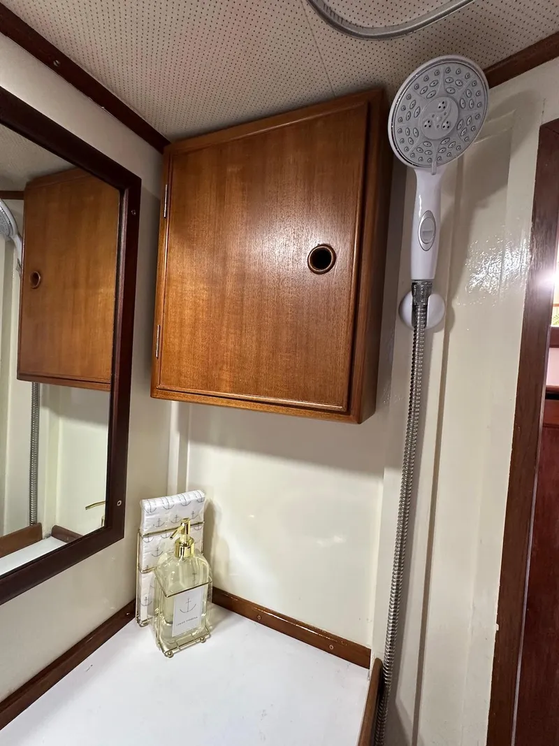 Slide: The Image of 1974 Grand Banks 32 Sedan interior with wooden cabinet and showerhead. - 37
