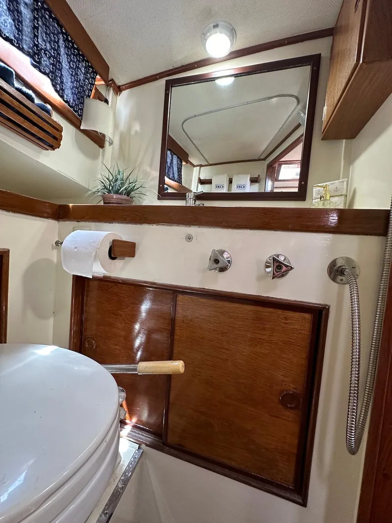 Slide: The Image of 1974 Grand Banks 32 Sedan bathroom with wooden accents and nautical decor. - 39