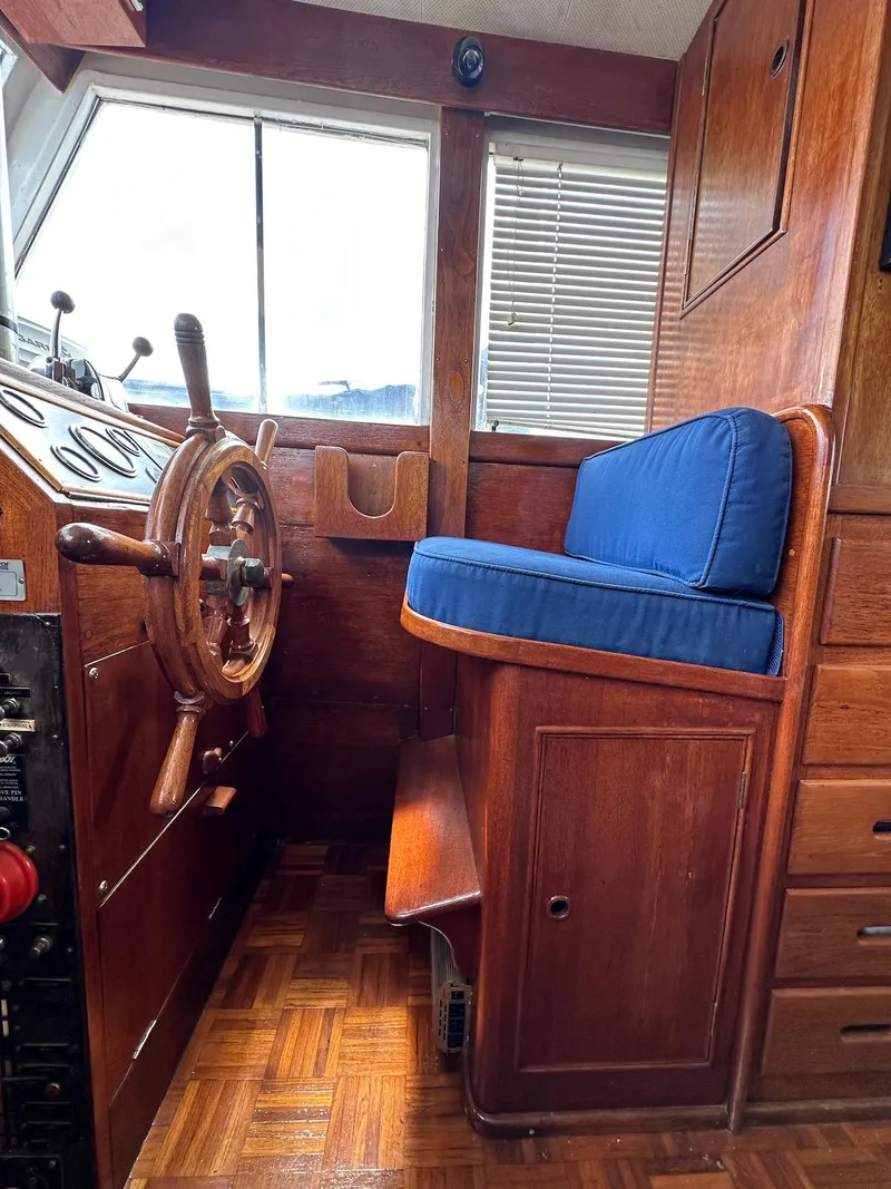 Slide: The Image of 1974 Grand Banks 32 Sedan helm with wooden wheel and blue cushioned seat. - 41