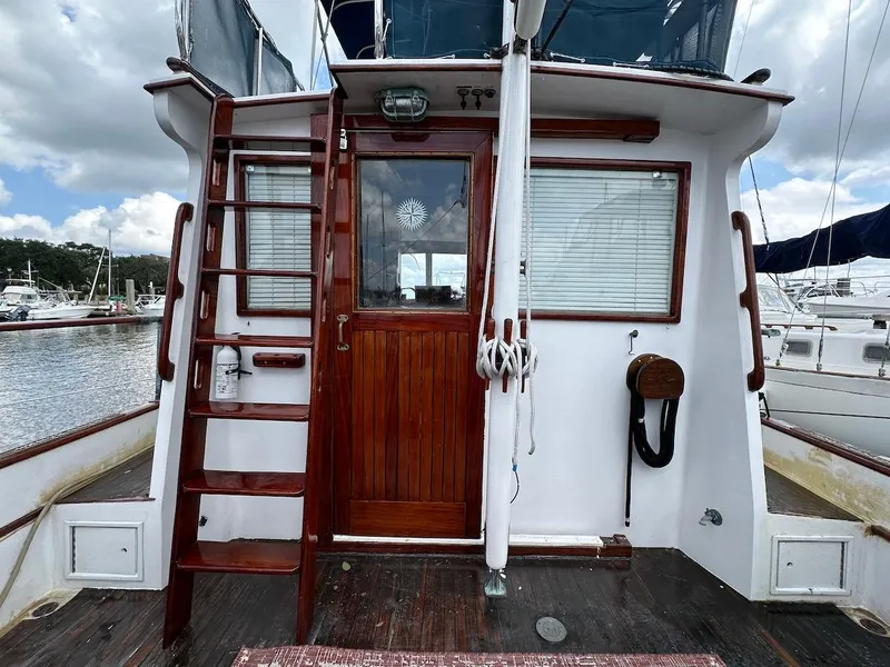 Slide: The Image of 1974 Grand Banks 32 Sedan boat stern with wooden ladder and door, docked at marina. - 7