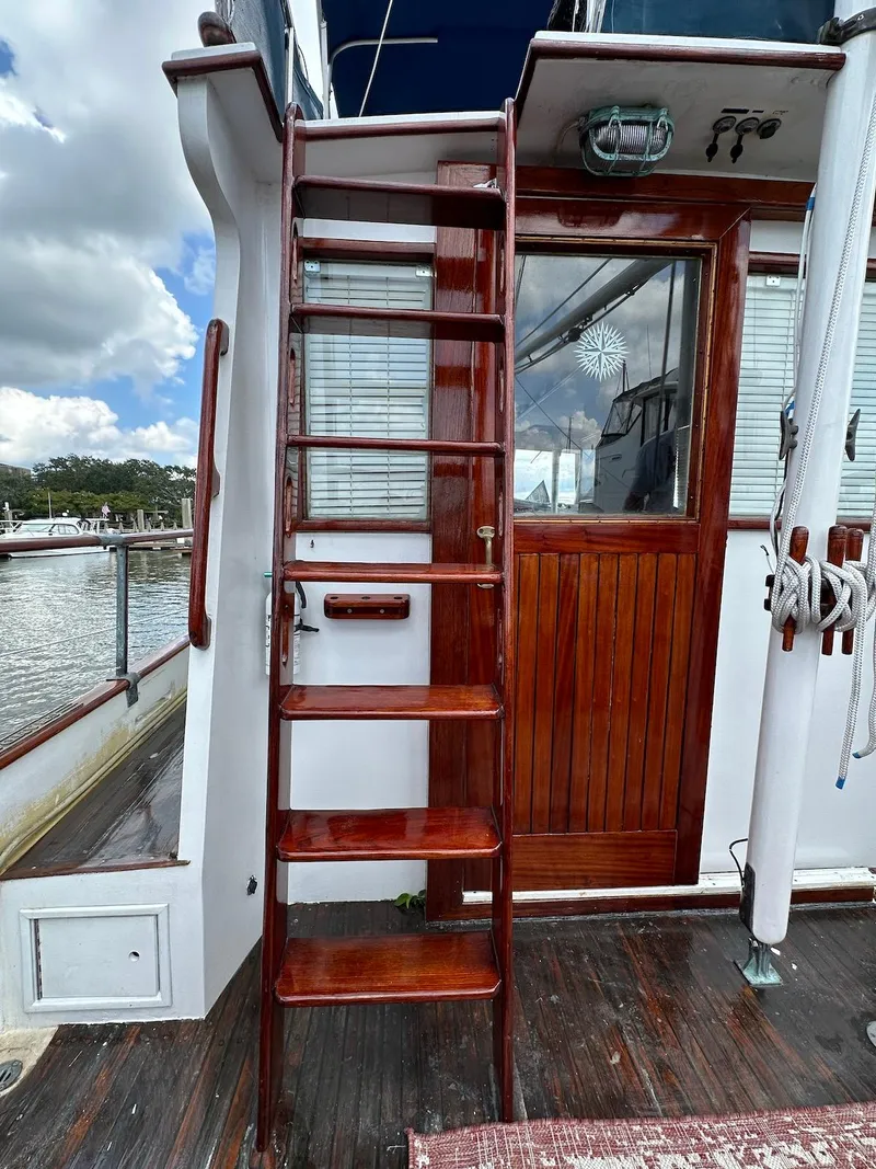 Slide: The Image of 1974 Grand Banks 32 Sedan with wooden ladder and door, docked by the water. - 8