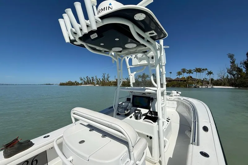 Slide: The Image of 2017 Yellowfin 26 Hybrid boat on calm water, featuring advanced navigation equipment. - 18