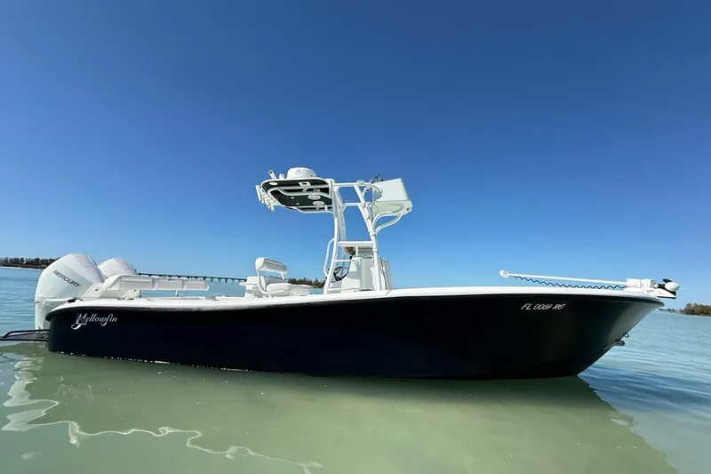 Slide: The Image of 2017 Yellowfin 26 Hybrid boat on calm water under clear blue sky. - 2