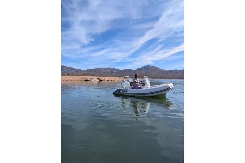 Slide: The Image of Tide Craft Beaver 10 boat on a serene lake, 2026 model, with scenic mountain backdrop. - 10