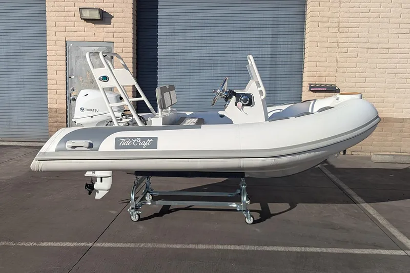 Slide: The Image of Manufacturer Provided Image: 2025 Tide Craft Beaver 10 inflatable boat with Tohatsu engine, parked outdoors. - 5