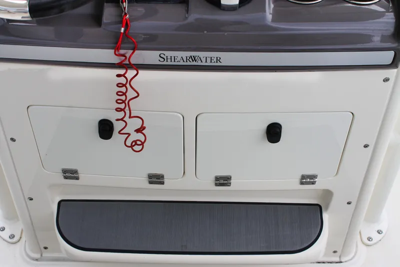Slide: The Image of 2024 ShearWater 270 SS Open Carolina boat console with storage compartments and safety lanyard. - 24