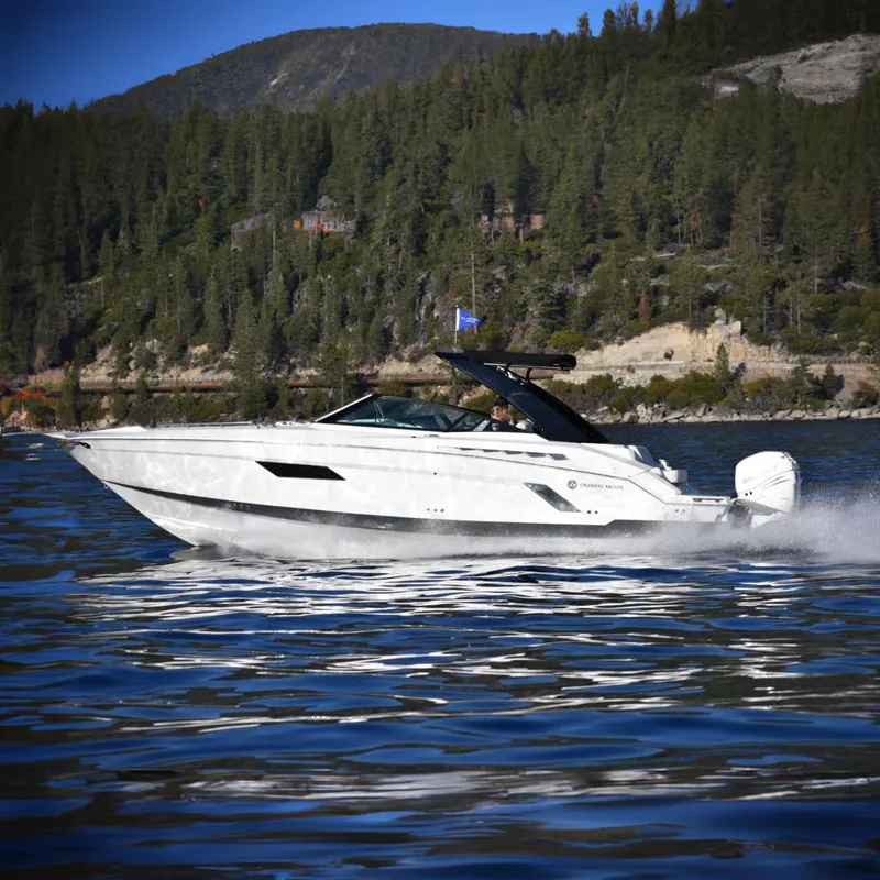 Slide: The Image of 2020 Cruisers Yachts 338OB speeding on a scenic lake with forested hills. - 3