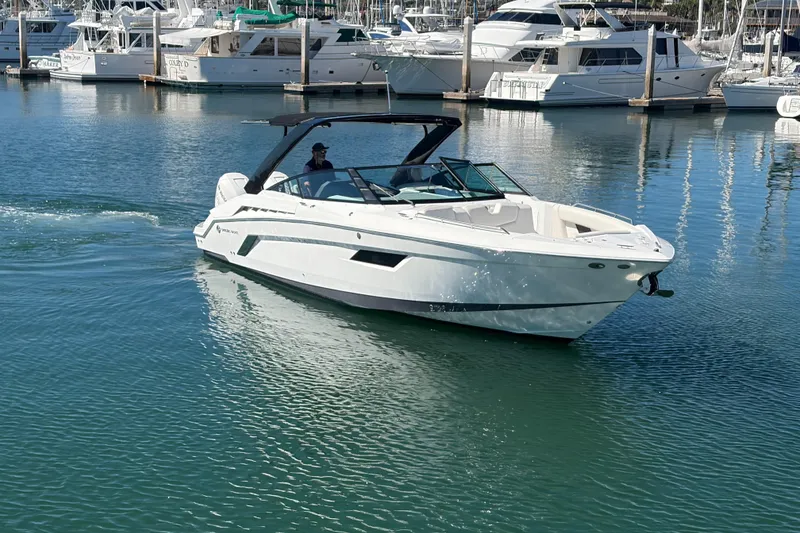 Slide: The Image of 2020 Cruisers Yachts 338 Outboard in marina, surrounded by other boats. - 30