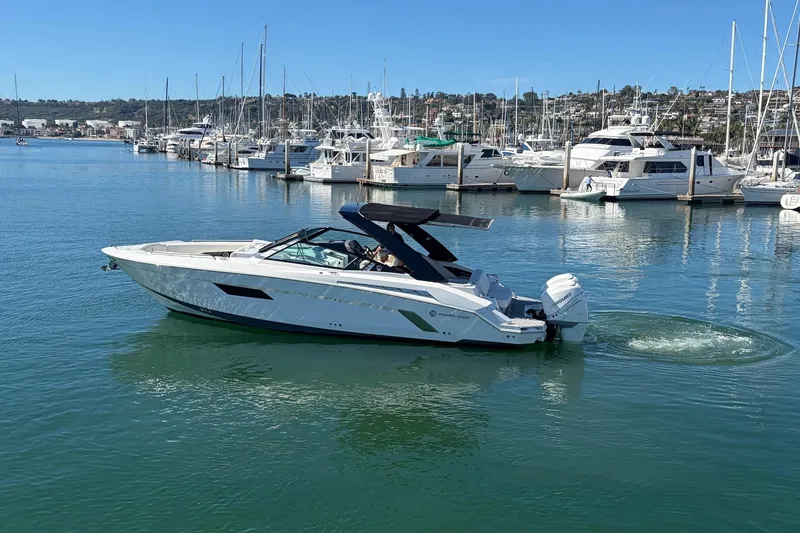 Slide: The Image of 2020 Cruisers Yachts 338 Outboard in marina, surrounded by boats, under clear blue sky. - 32
