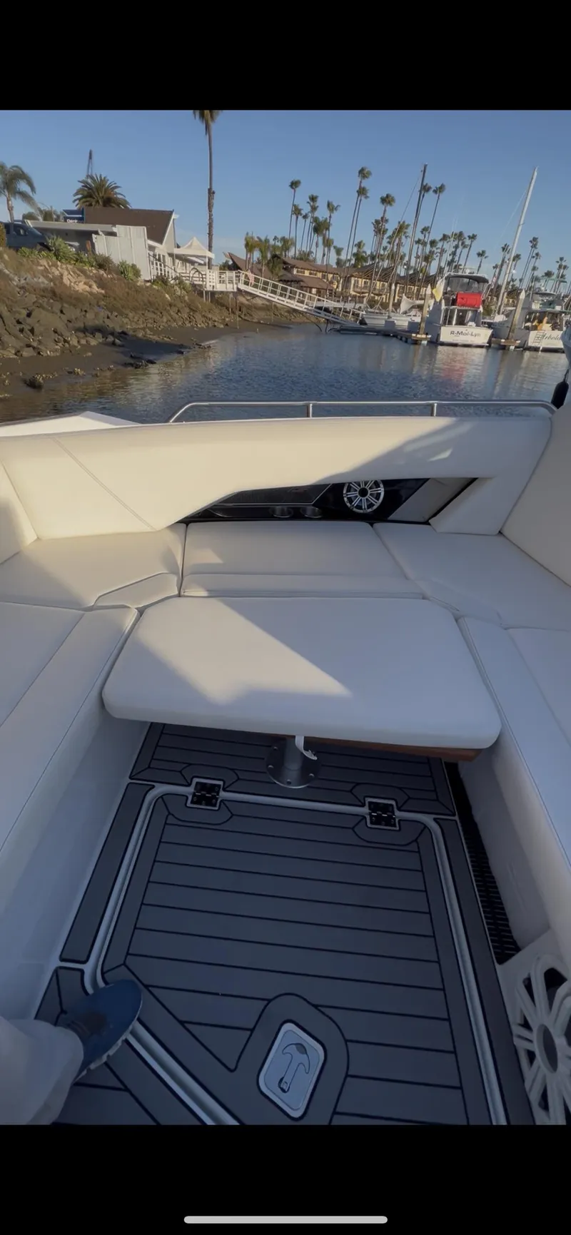 Slide: The Image of 2020 Cruisers Yachts 338OB interior with white seating and waterfront view. - 6