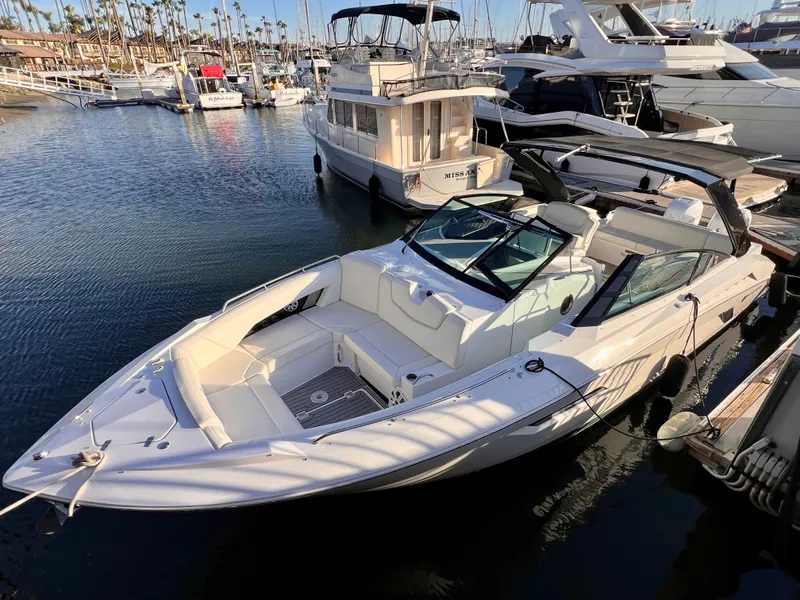 Slide: The Image of 2020 Cruisers Yachts 338OB docked in a marina, surrounded by other boats. - 1
