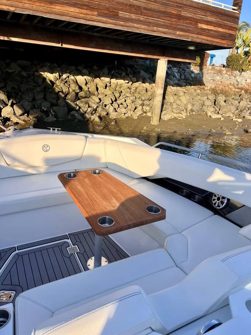 Slide: The Image of 2020 Cruisers Yachts 338OB boat interior with wooden table and white seating. - 5