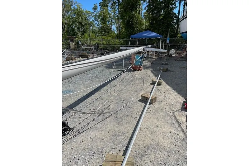 Slide: The Image of Sailboat mast and rigging on ground, Caliber 38, 1988 model, in a boatyard setting. - 14