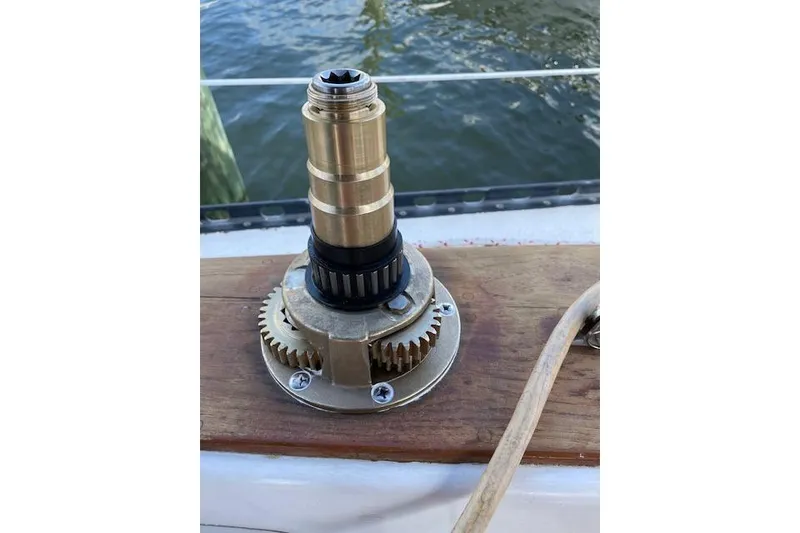 Slide: The Image of Brass winch mechanism on a 1988 Caliber 38 sailboat deck by the water. - 18