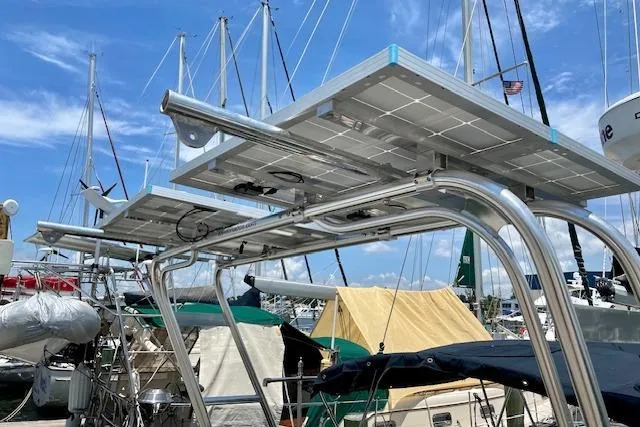 Slide: The Image of Solar panels on a 1988 Caliber 38 sailboat, docked at a marina under a clear sky. - 21