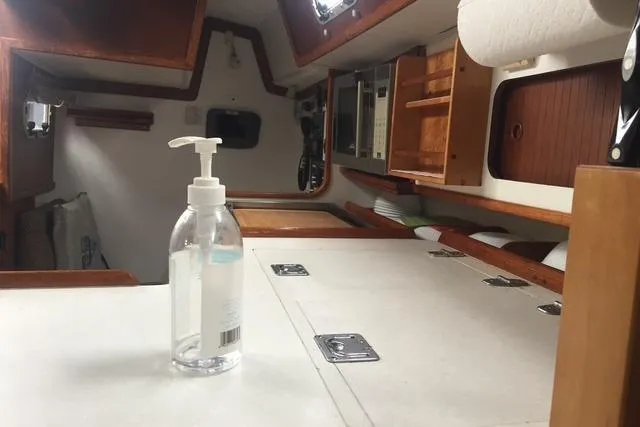 Slide: The Image of Interior of a 1988 Caliber 38 sailboat with a hand sanitizer bottle on the counter. - 4