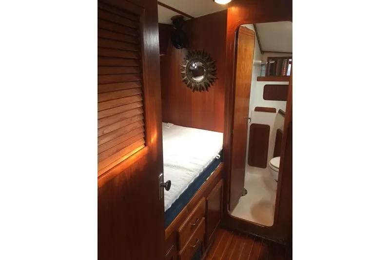 Slide: The Image of 1988 Caliber 38 yacht interior with wooden cabin, bed, and bathroom. - 7
