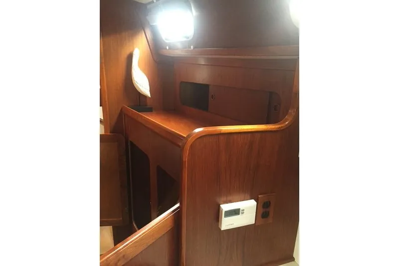 Slide: The Image of Interior of 1988 Caliber 38 sailboat with wooden cabinetry and decorative accents. - 8