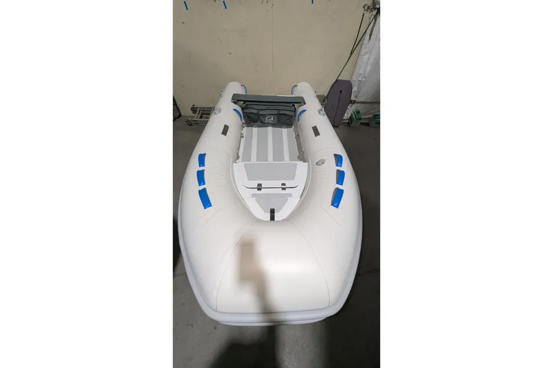 Slide: The Image of 2025 Zodiac Nomad 3.3 RIB Alu inflatable boat in a garage setting. - 3