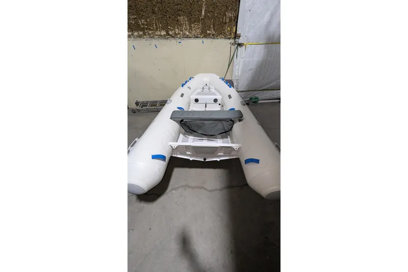 Slide: The Image of 2025 Zodiac Nomad 3.3 RIB Alu inflatable boat in a storage area. - 8