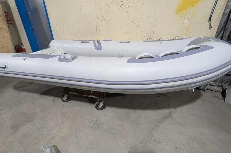 Slide: The Image of 2025 Zodiac Cadet RIB Alu 330 inflatable boat in a storage area. - 5