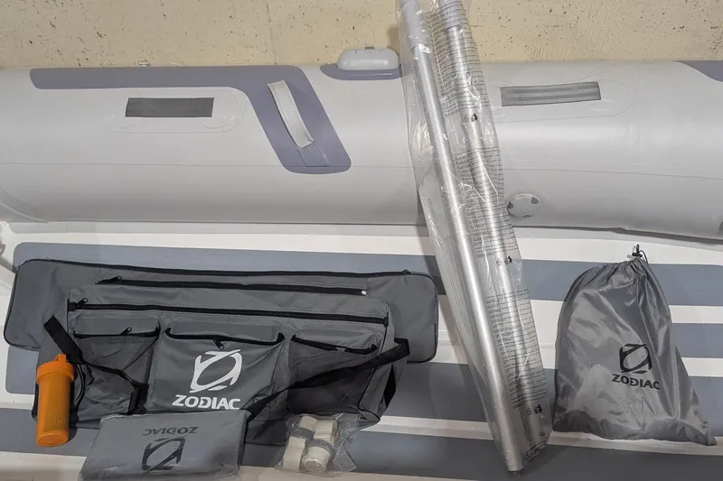 Slide: The Image of 2025 Zodiac Cadet RIB Alu 330 accessories, including bags and equipment, displayed on inflatable boat. - 9