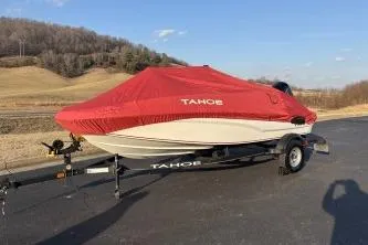 Slide: The Image of 2023 Tahoe T16 boat with red cover on trailer, parked outdoors. - 13