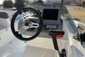 Slide: The Image of 2023 Tahoe T16 boat dashboard with steering wheel and control panel. - 2