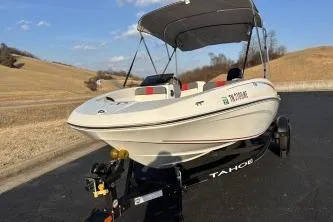 Slide: The Image of 2023 Tahoe T16 boat on trailer, parked on a rural road under a clear sky. - 5