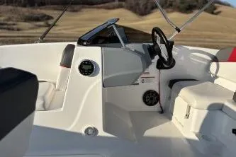 Slide: The Image of 2023 Tahoe T16 boat interior with steering wheel and seating, set against a scenic background. - 8