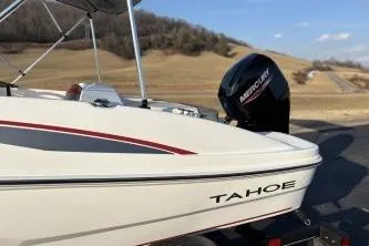 Slide: The Image of 2023 Tahoe T16 boat with Mercury engine on a trailer, scenic background. - 9