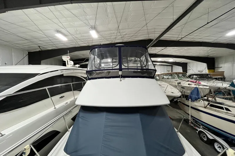 Slide: The Image of 1995 Carver 325 Aft Cabin Motor Yacht in indoor storage, surrounded by other boats. - 11
