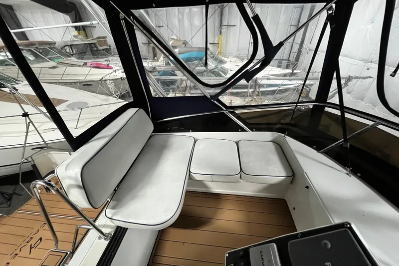 Slide: The Image of 1995 Carver 325 Aft Cabin Motor Yacht interior with white seating and wood flooring. - 9