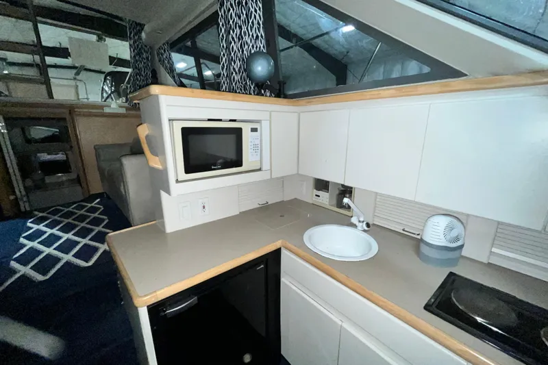 Slide: The Image of 1995 Carver 325 Aft Cabin Motor Yacht interior kitchen with microwave, sink, and cabinets. - 16