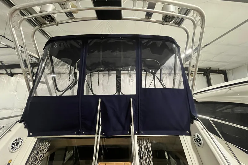 Slide: The Image of 1995 Carver 325 Aft Cabin Motor Yacht with blue canvas enclosure in a storage facility. - 6