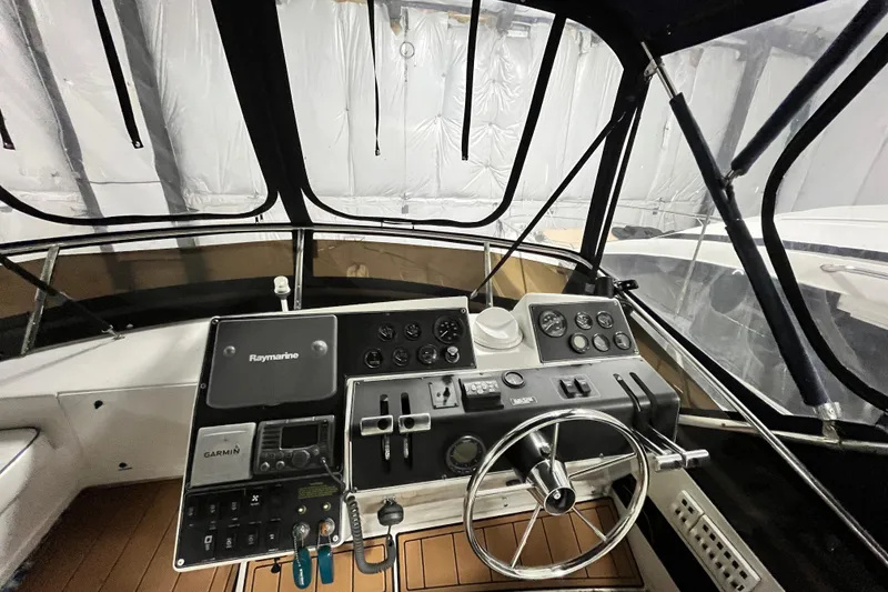 Slide: The Image of 1995 Carver 325 Aft Cabin Motor Yacht helm with navigation equipment and steering wheel. - 7