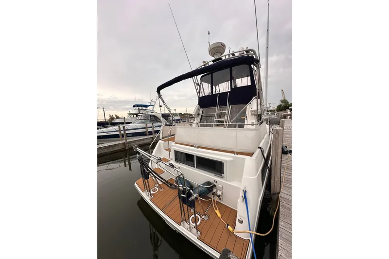 Slide: The Image of 1995 Carver 325 Aft Cabin Motor Yacht docked at marina, rear view. - 1