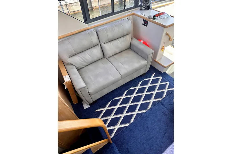Slide: The Image of Gray sofa in 1995 Carver 325 Aft Cabin Motor Yacht interior, with blue patterned rug. - 5