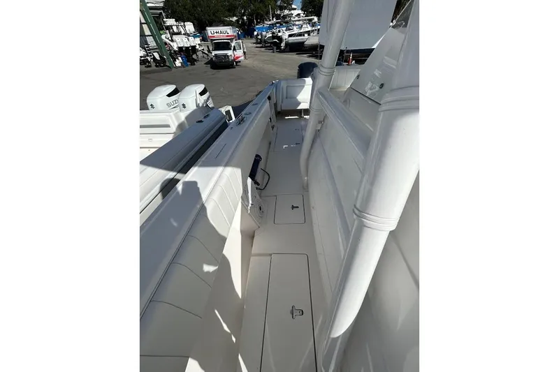 Slide: The Image of 2014 Intrepid 327 Center Console boat interior with white seating and storage compartments. - 11
