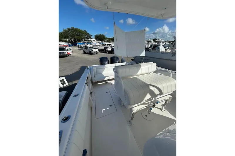 Slide: The Image of 2014 Intrepid 327 Center Console boat with white seating, docked under clear blue skies. - 12